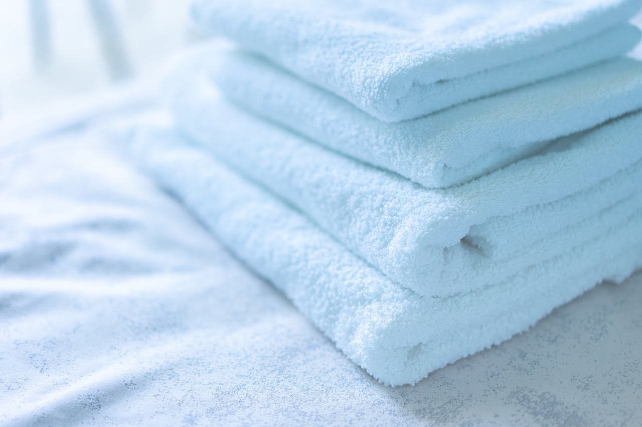 Soft white towels neatly stacked, ideal for spa or bathroom decor themes.