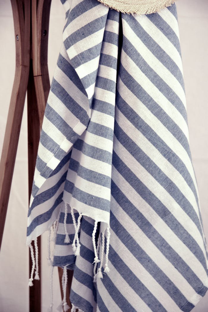 Artistic display of a blue and white striped beach towel hanging outdoors.